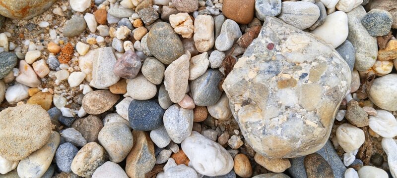 A neat pile of weathered river rocks sorted by color gradients, presenting a visually satisfying pattern for creative agencies