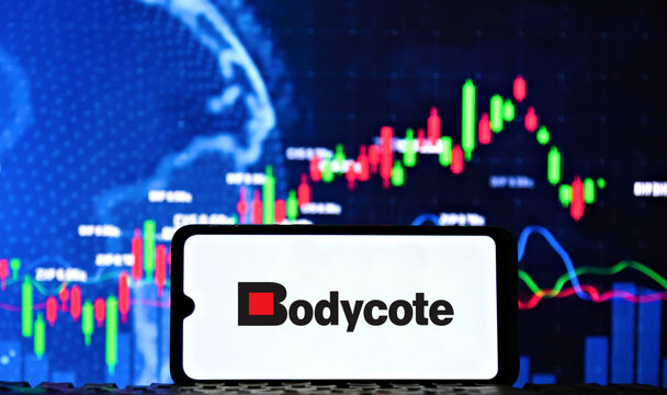 Bodycote plc company logo displayed on smartphone screen with financial stock market graphs and charts in the background