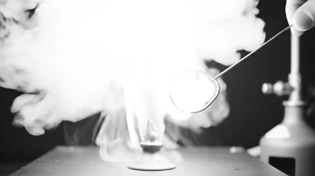 Dramatic slow-motion view of a flame igniting a chemical substance resulting in a white smoke explosion