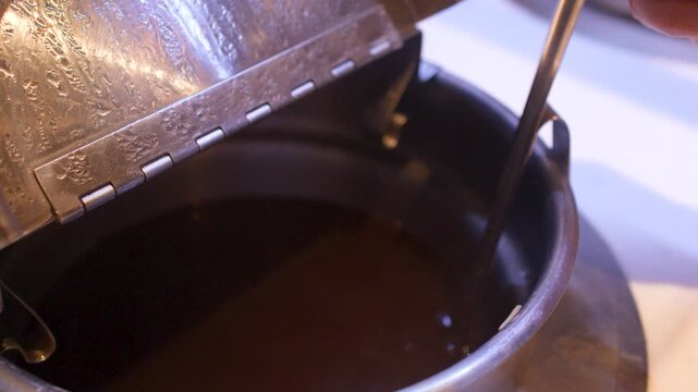 Hand Opening Metal Pot and Stirring Hot Soup with Ladle
