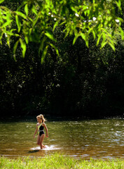 Fototapeta premium Happy teenager girl is having fun and enjoying life during her summer vacation. She’s swimming, dressed in a bathing suit. Carefree girl smiling cheerfully as she embraces the joy of travel