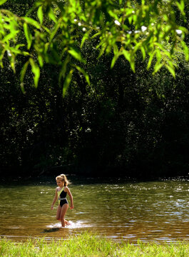 Happy teenager girl is having fun and enjoying life during her summer vacation. She’s swimming, dressed in a bathing suit. Carefree girl smiling cheerfully as she embraces the joy of travel