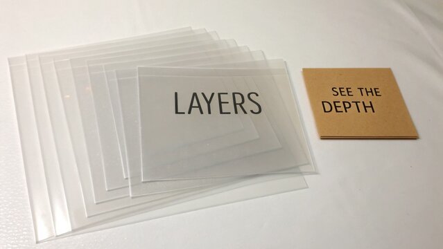 Transparent overlays with printed text demonstrating layering concept and depth perception for educational or artistic use