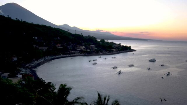 Aerial sunset view overlooking Jemeluk Bay with local fishing boats and Mt Agung volcano in Amed on tropical island Bali, Indonesia