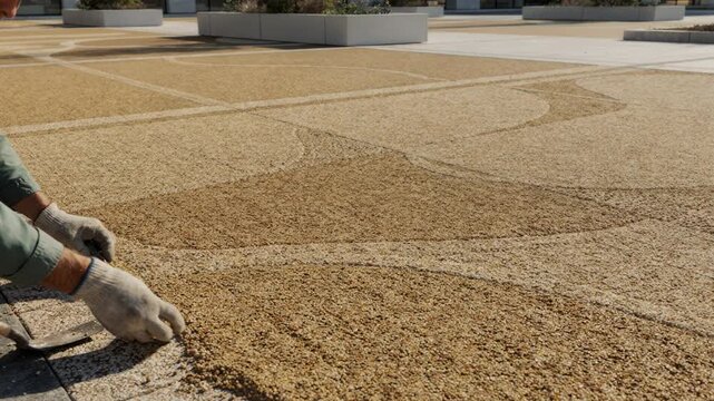 Detailed medium perspective of tancolored asphalt mixture preparation for a stylish plaza floor highlighting elegant decorative outdoor flooring solutions.