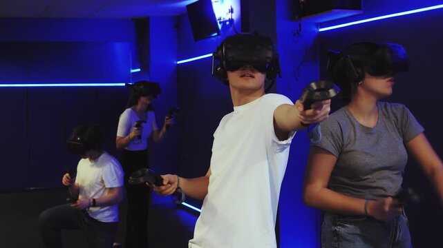 Emotional joyful boy and girl in virtual glasses plays a game by controlling joysticks