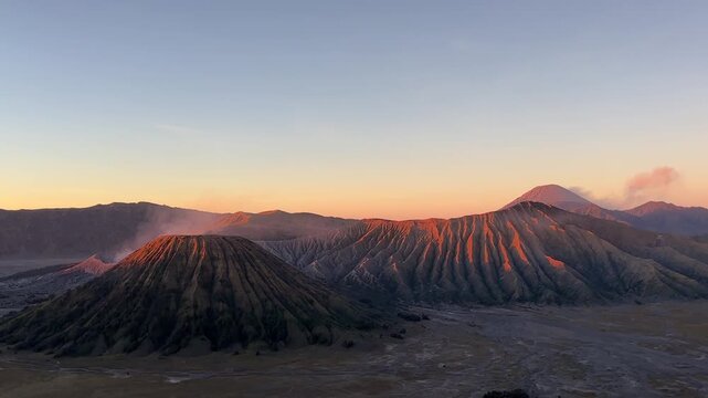 Stunning golden sunrise over Mount Bromo volcano complex in East Java Indonesia featuring majestic crater ridges and dawn sky