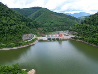 Obraz premium Dam on the lake A peaceful mountain river landscape view in nature with green forest trees, water, and clouds in the summer sky