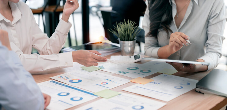 Business team analyzing financial documents and charts during meeting.