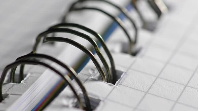 Close-up of a spiral-bound notebook, showing the metal binding