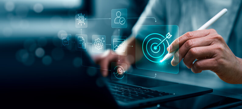 Business person using stylus and laptop with virtual AI workflow process icons showing automation steps data analysis user verification and target objective in modern digital workspace