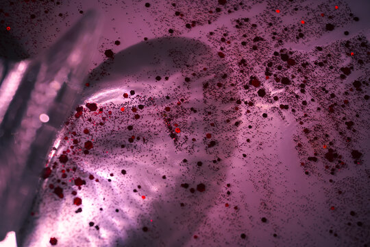 Vibrant pink reflections and sparkling red glitter shimmering in the night, creating a glamorous luxury texture perfect for festive backgrounds and commercial design.