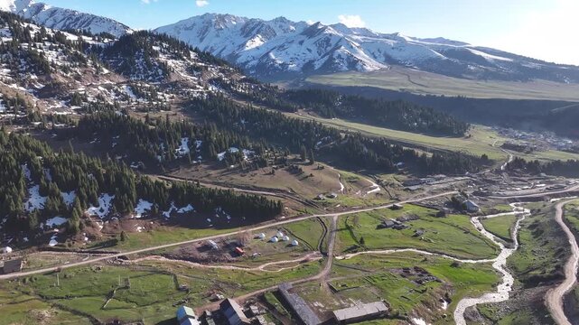 Drone flying to small yurt camp in the Kyrgyzstan mountains near Jyrgalan. Golden light