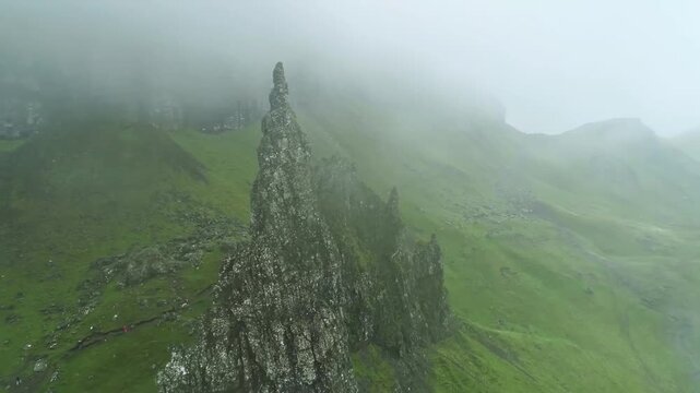 Cinematic drone footage slowly flying through low clouds and mist over the rugged mountains of the Scottish Highlands. The aerial camera glides smoothly through the atmospheric landscape, revealing dr