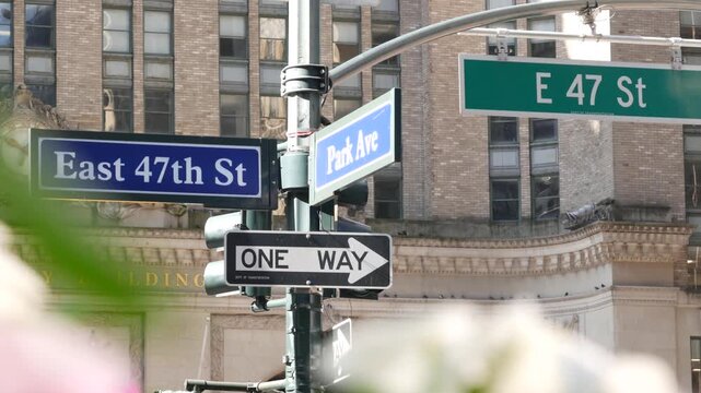 New York Park Avenue, 47 street sign, Manhattan Midtown, United States. Urban road sign in american city, traffic sign in NYC, USA. Building architecture near Grand Central. Flower blossom, flowerbed.