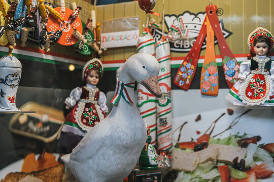 Traditional folk souvenirs with decorative goose figure and colorful handmade dolls at market stall
