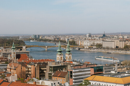 High angle view of historic church spires and river cruise along European city waterfront