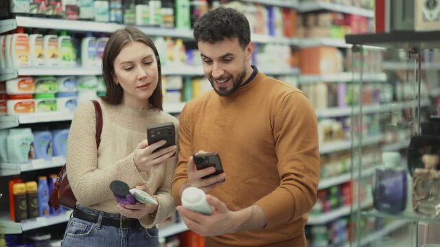 Young man and woman uses smartphone to scan QR code on care products in supermarket