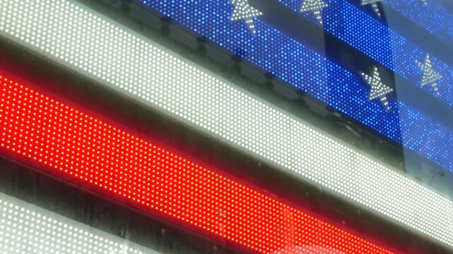 American flag on Broadway, Times Square in New York City, United States. Electric lights glowing. Symbol of democracy, national attribute of USA. 4th July or 911 September 11 concept. Military Island.
