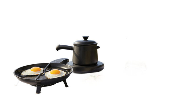Fried eggs skillet breakfast. Two sunny-side-up eggs frying in a cast-iron pan and black pot on a transparent background