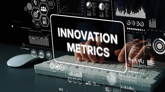 Hands typing on a keyboard with a digital screen displaying innovation metrics and data visualizations in a modern office setting. Asymptotic smart data analytic.