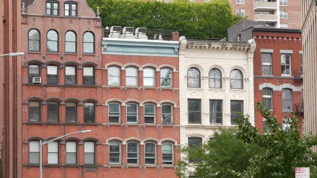 New York City urban residential buildings architecture, Lower Manhattan historic classic street, United States of America. Typical old red brick house in NYC, real estate property in USA. Windows.