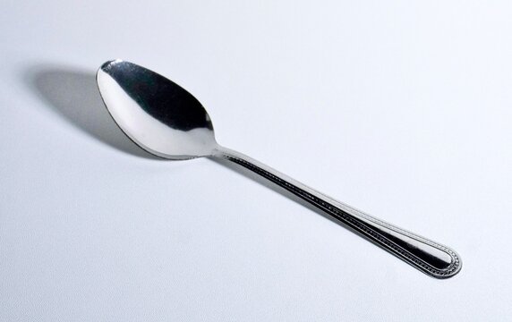 One silver spoon isolated on horizontal plain background.