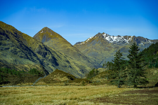 A beautiful landscape featuring a snow-capped mountain range in the Scottish Highlands in spring