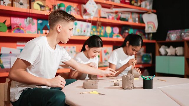 Group of happy smart diverse student working with clay art at pottery workshop. Multicultural attractive high school student modeling, smash, playing clay. Creativity activity concept. Edification