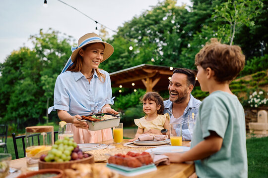 Happy family enjoying while having lunch on patio.