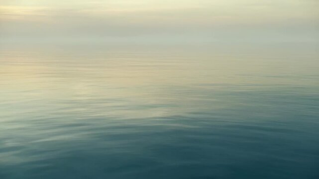 Calm water surface gently rippling under a soft sky. Reflecting a serene and balanced natural environment.