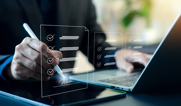 Business professional signing digital checklist and electronic document on tablet with laptop. Online approval, e-signature, workflow management, compliance audit and paperless business process.