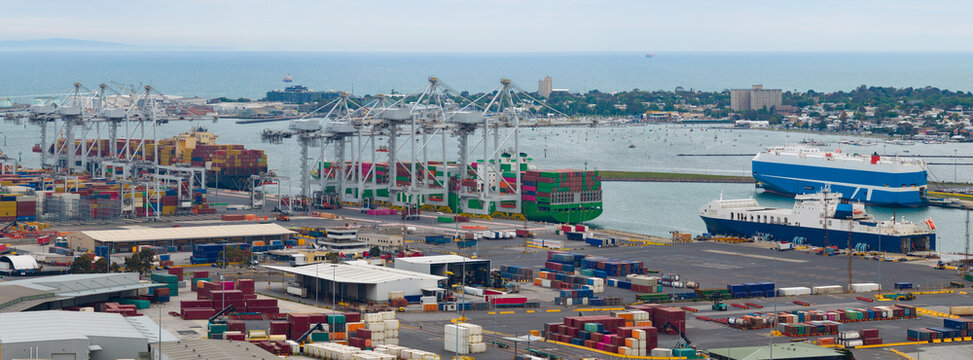 Aerial panorama view of large cranes loading cargo ships at a city port