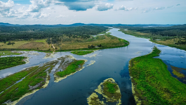 Aerial view of a winding river cutting through a lush, green landscape