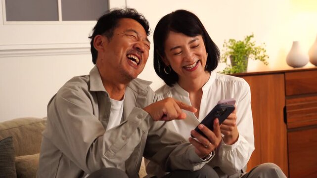 スマホを見て笑い合う熟年夫婦