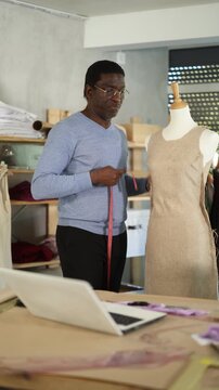 African man seamstress communicates with customer via video call work with mannequin. Contractor clarifies details with customer, discusses work issues.