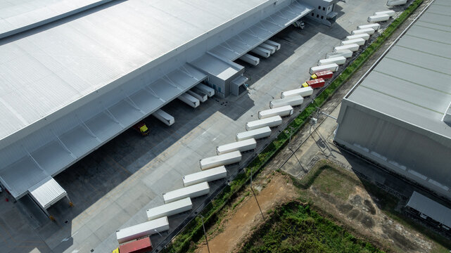 Aerial view modern warehouse for trucks unloading and loading, semi truck cargo trailer at logistic park warehouse, Distribution warehouse shipping supply chain, Business transportation logistic.