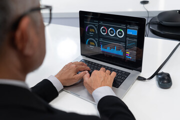 Data analysis and visualization in a professional environment using a laptop with multiple chart...