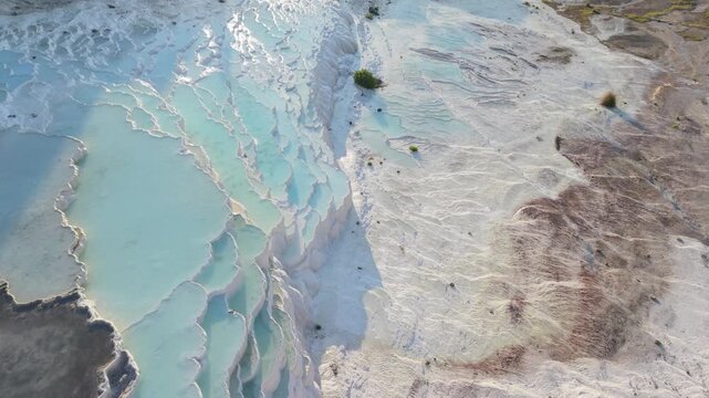 Explore the mesmerizing beauty of Pammukale, Turkey, showcasing the remarkable white travertine terraces and serene turquoise pools. Perfect location for relaxation and sightseeing.