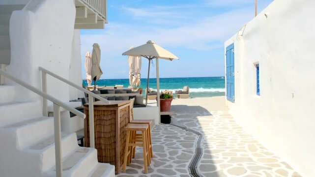 Delight in the picturesque streets of Paros Greece, where charming cafes overlook the vibrant blue sea. Relaxation and sunshine create an idyllic atmosphere for visitors seeking a perfect vacation.