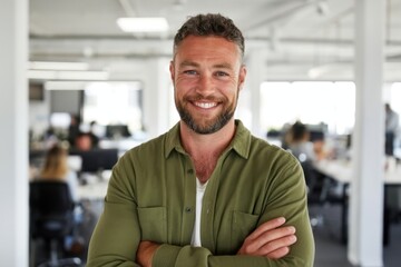 Obraz premium The man smiling confidently with folded arms in a modern open office environment