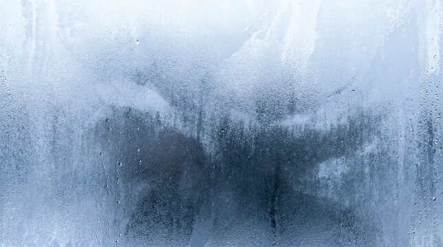 clear water drops condensation forming upon cold glass window showing beautiful icy blue frosted texture macro abstract wet winter background freezing weather