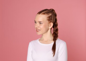 Obraz premium Smiling teenage girl with beautiful braids on pink background