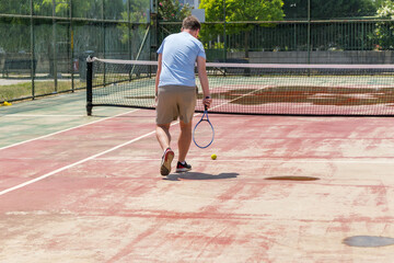 Obraz premium Tennis player serving on outdoor court. Concept of fitness, competition, athletic performance and healthy lifestyle.
