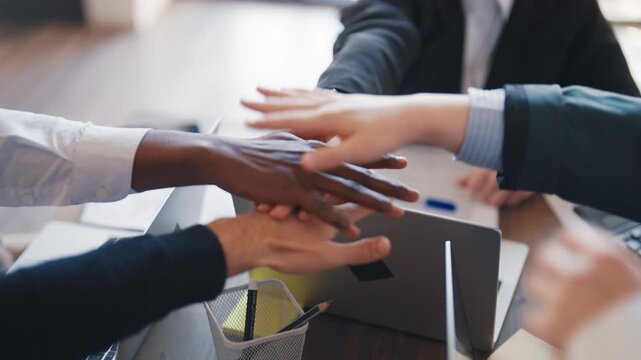Support of colleagues, diverse people connecting hands before important deal. Working day in office, coworkers discussing ideas in conference room, be together, teamwork and corporate culture