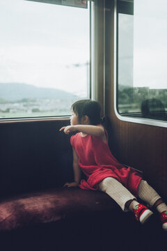 電車で車窓を眺める女の子