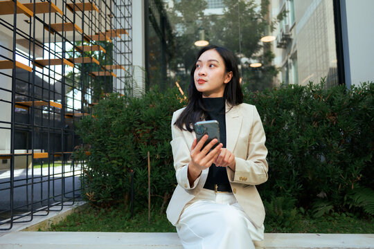 Young businesswoman using smartphone in modern city environment