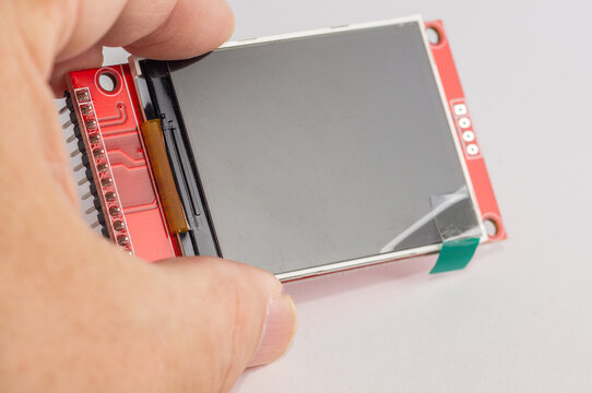 Close-up of an OLED display for microcontroller devices held in a hand.