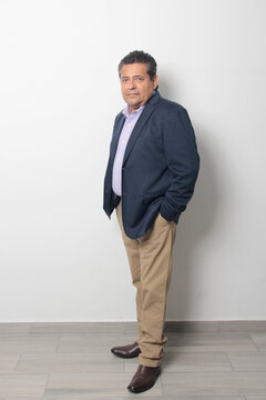 60-year-old Latino man with dark skin appears happy and at peace, enjoying a successful professional and personal life