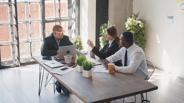 Successful business meeting in office, people smiling and giving five, good deal. Colleagues in co-working, multiracial people communicating for achieve goal, communication and business negotiation
